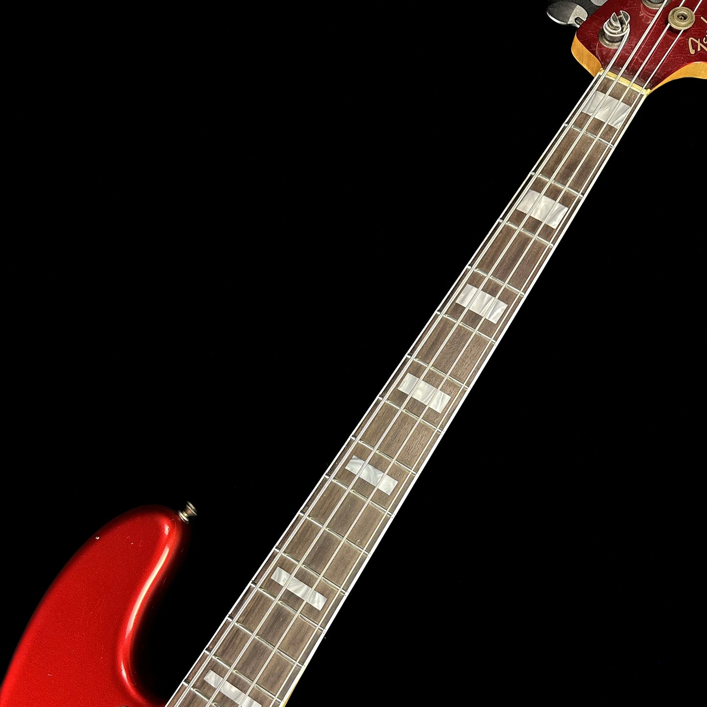 Closeup of Fender Custom Shop Limited P Jazz Bass Journeyman Aged Candy Apple Red fretboard.