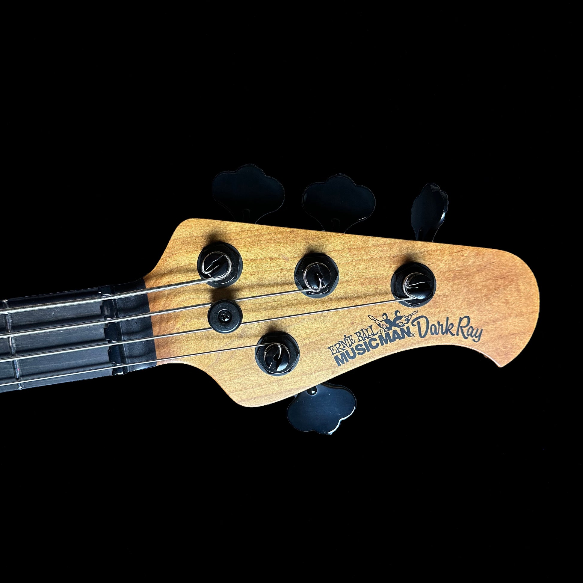 Close up of Ernie Ball Music Man DarkRay Bass Obsidian Black headstock.