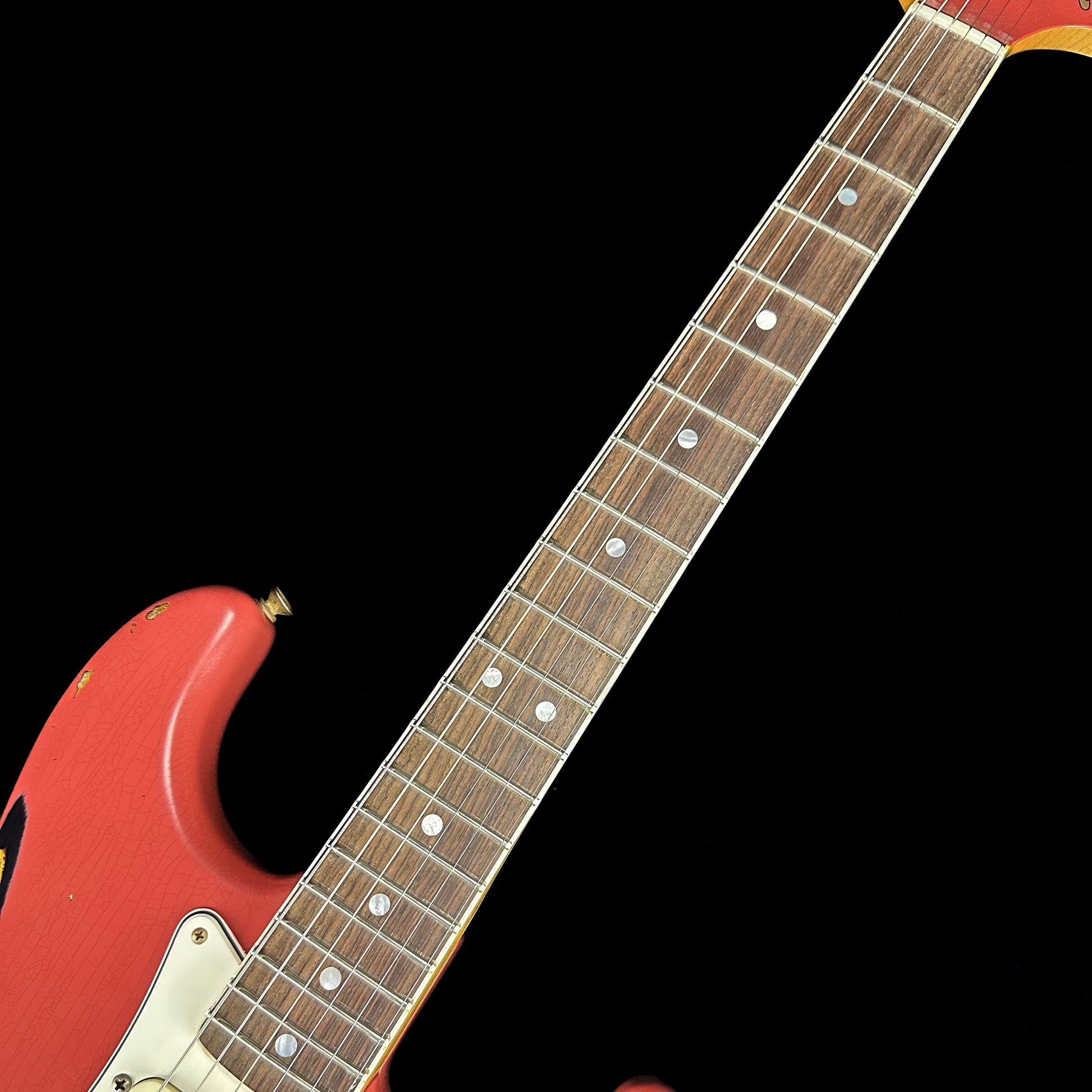 Front angle of Fender Custom Shop Limited 67 Stratocaster Heavy Relic Aged Fiesta Red/3-Tone Sunburst fretboard.