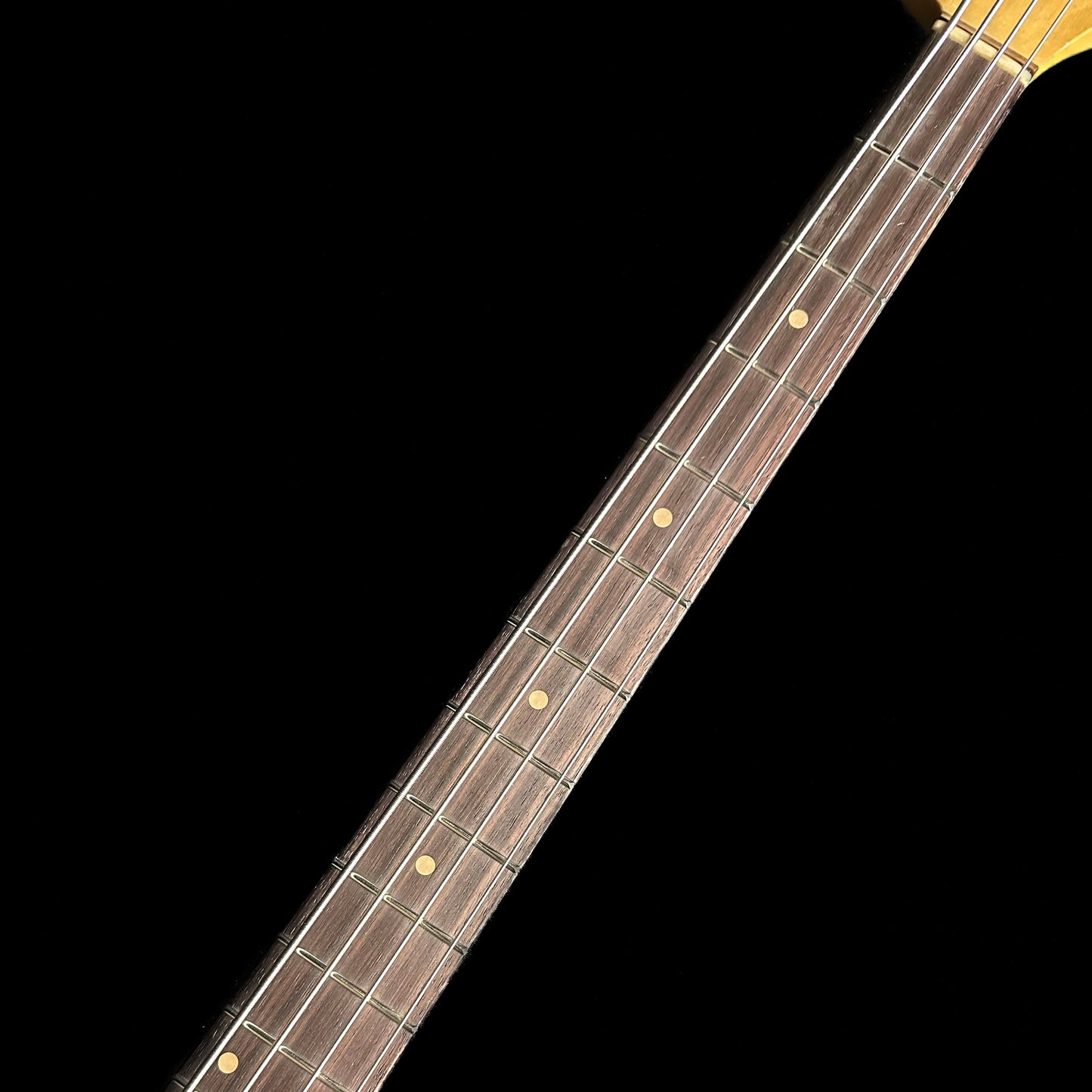 Closeup of Fender Custom Shop 1962 Jazz Bass Relic Aged Black fretboard.