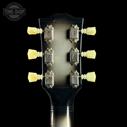 Close-up of a guitar headstock with tuning pegs on a black background, featuring the Tone Shop logo.