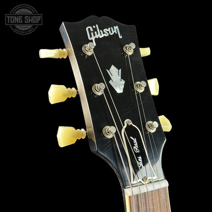 Gibson guitar headstock with tuning pegs on a black background