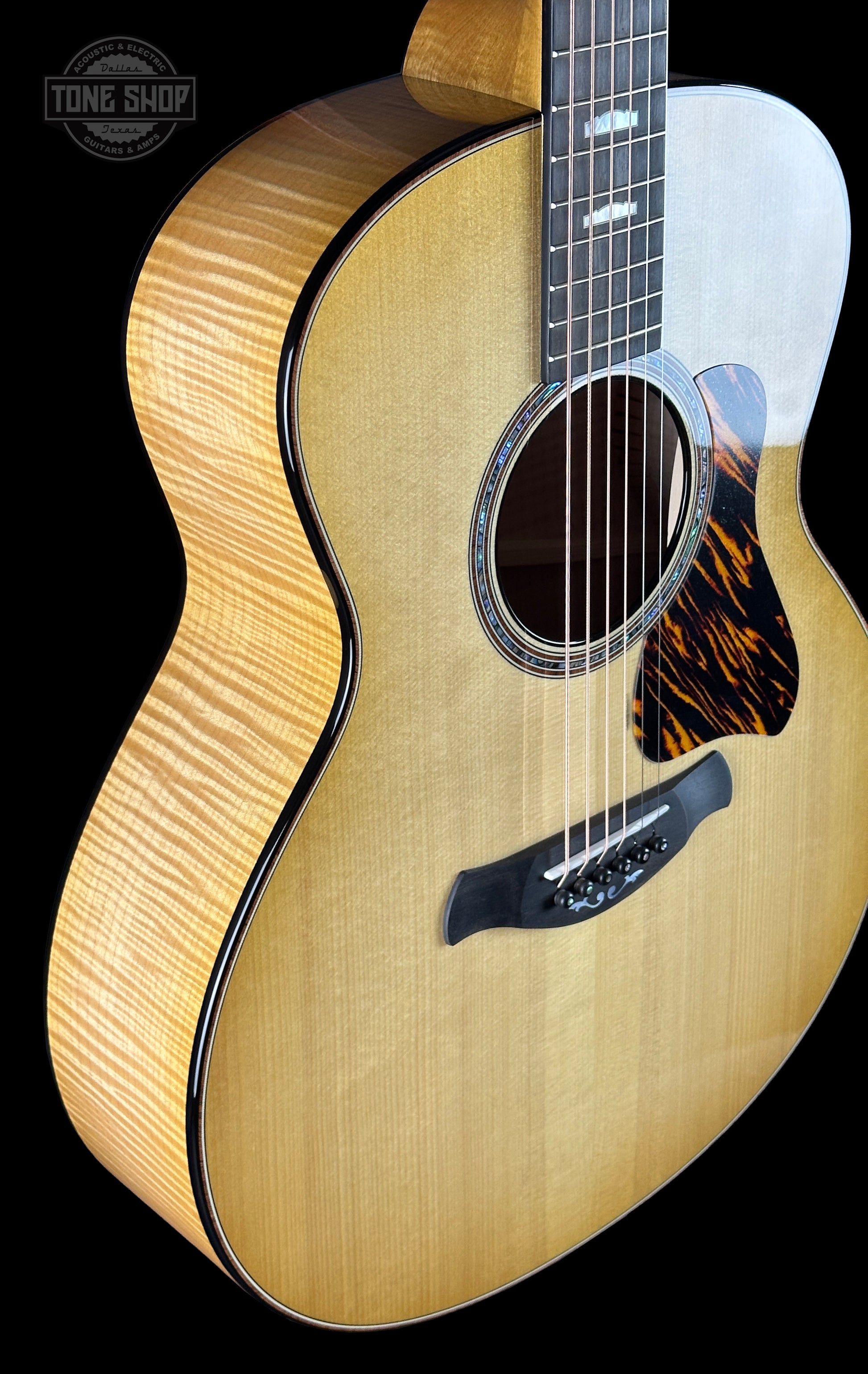 Acoustic guitar with a visible brand logo on a black background