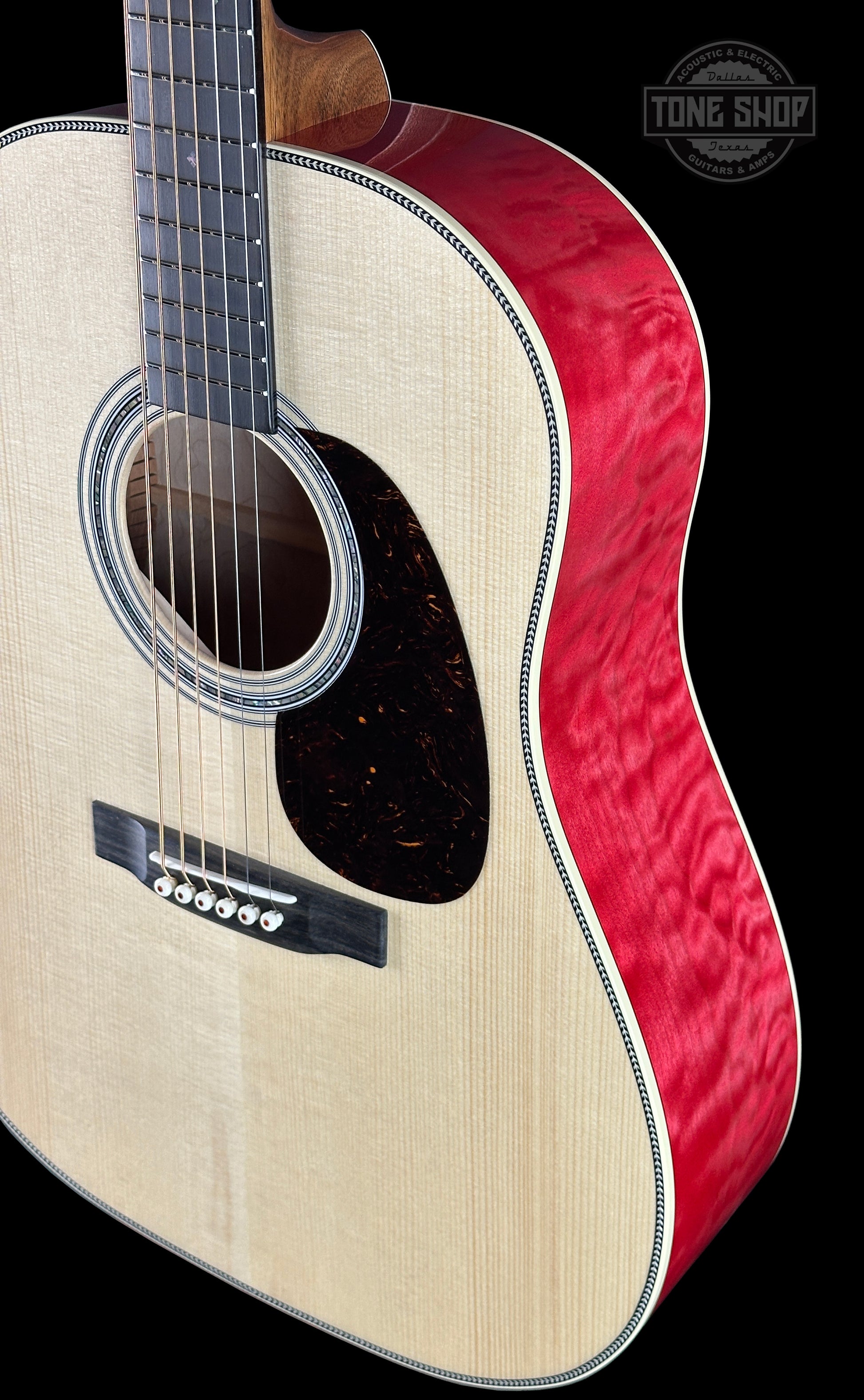 Acoustic guitar with red and white design on a black background