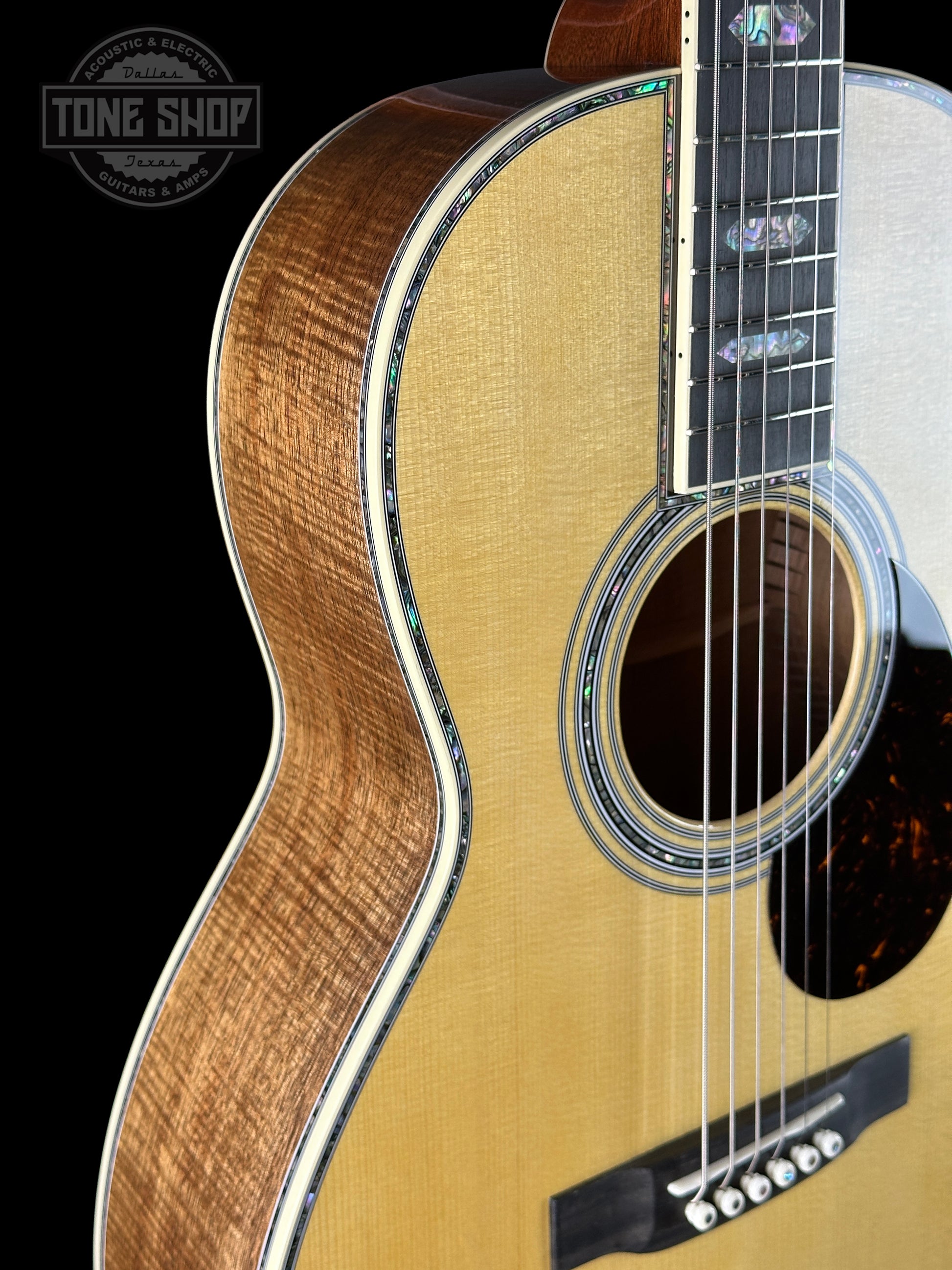 Close-up of an acoustic guitar with a visible brand logo in the corner.