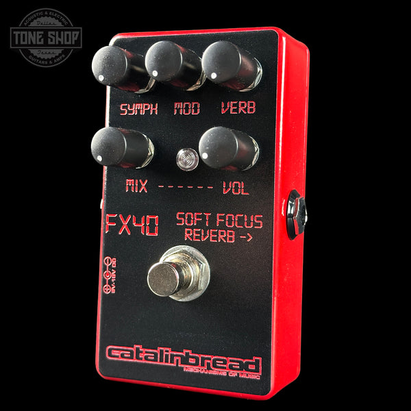Guitar effects pedal with red and black design on a black background