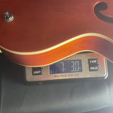 Used 2011 Gretsch Electromatic G5120 Orange Humbuckers on scale displaying weight.