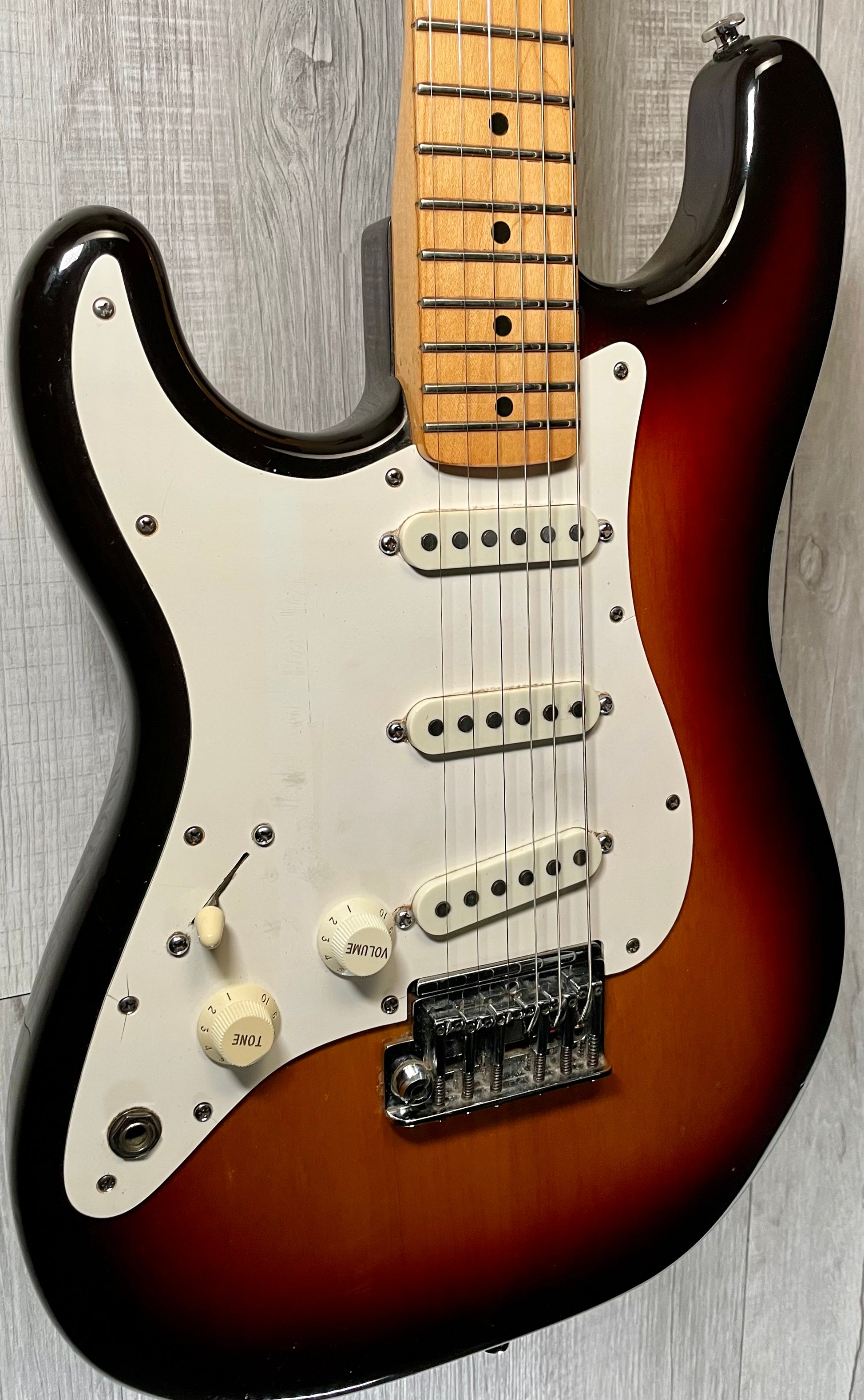 Front left angle of Used Vintage 1983 Fender Left Hand Stratocaster 3 Tone Sunburst TSS869.